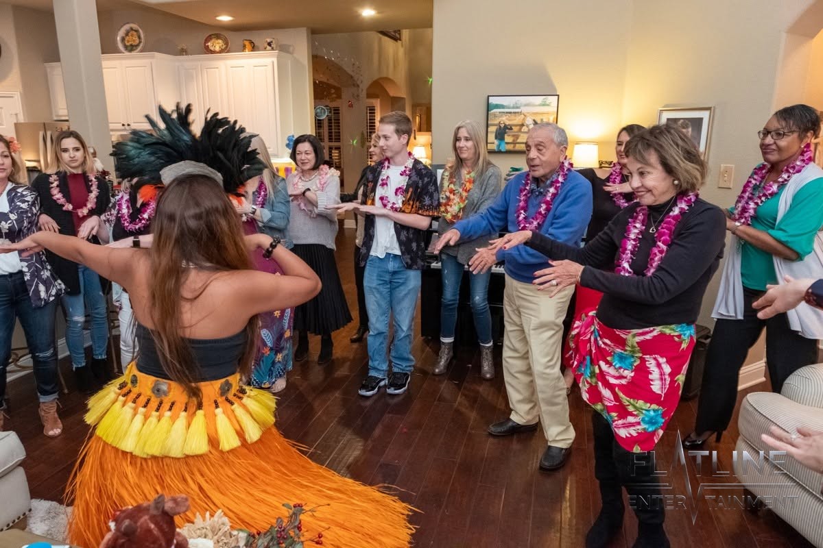 Guests dancing alongside a hula dancer at a birthday party