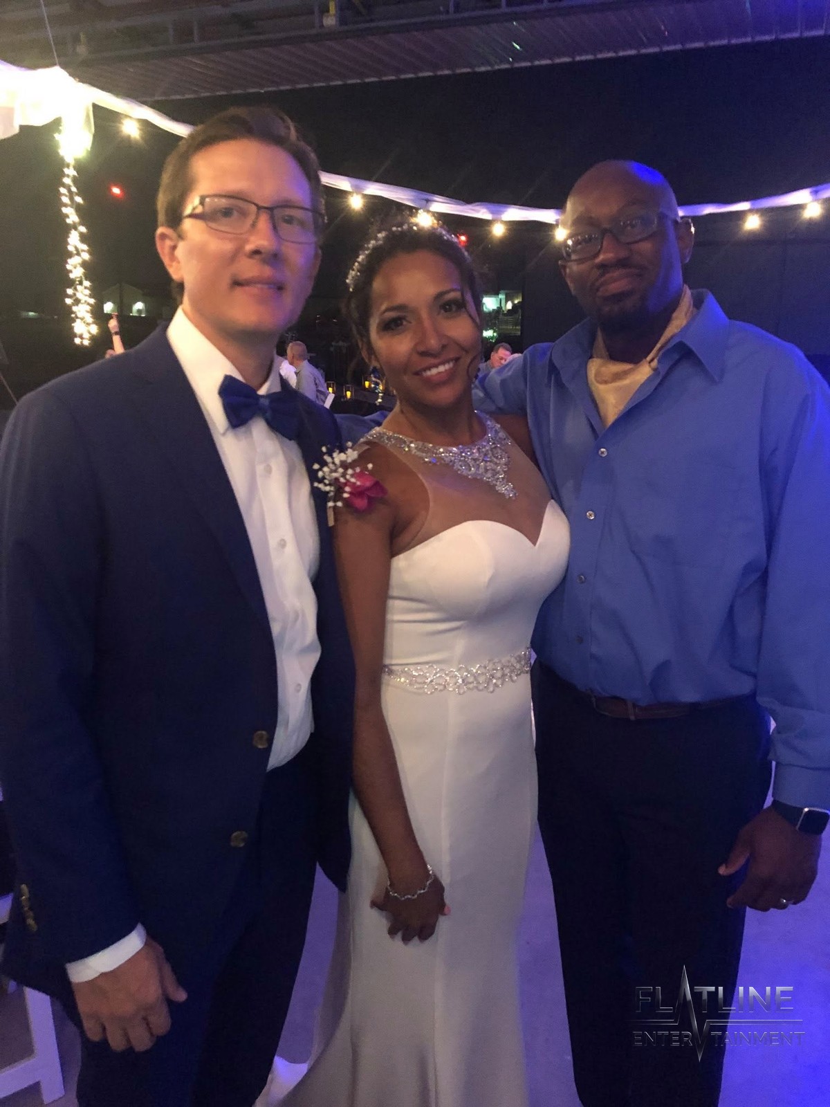 Liisa and Adam with a guest at their wedding, smiling